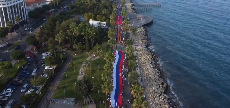 Тысячи жителей кипрского Лимасола 9 Мая развернули многометровый флаг РФ, георгиевскую ленту и Знамя Победы